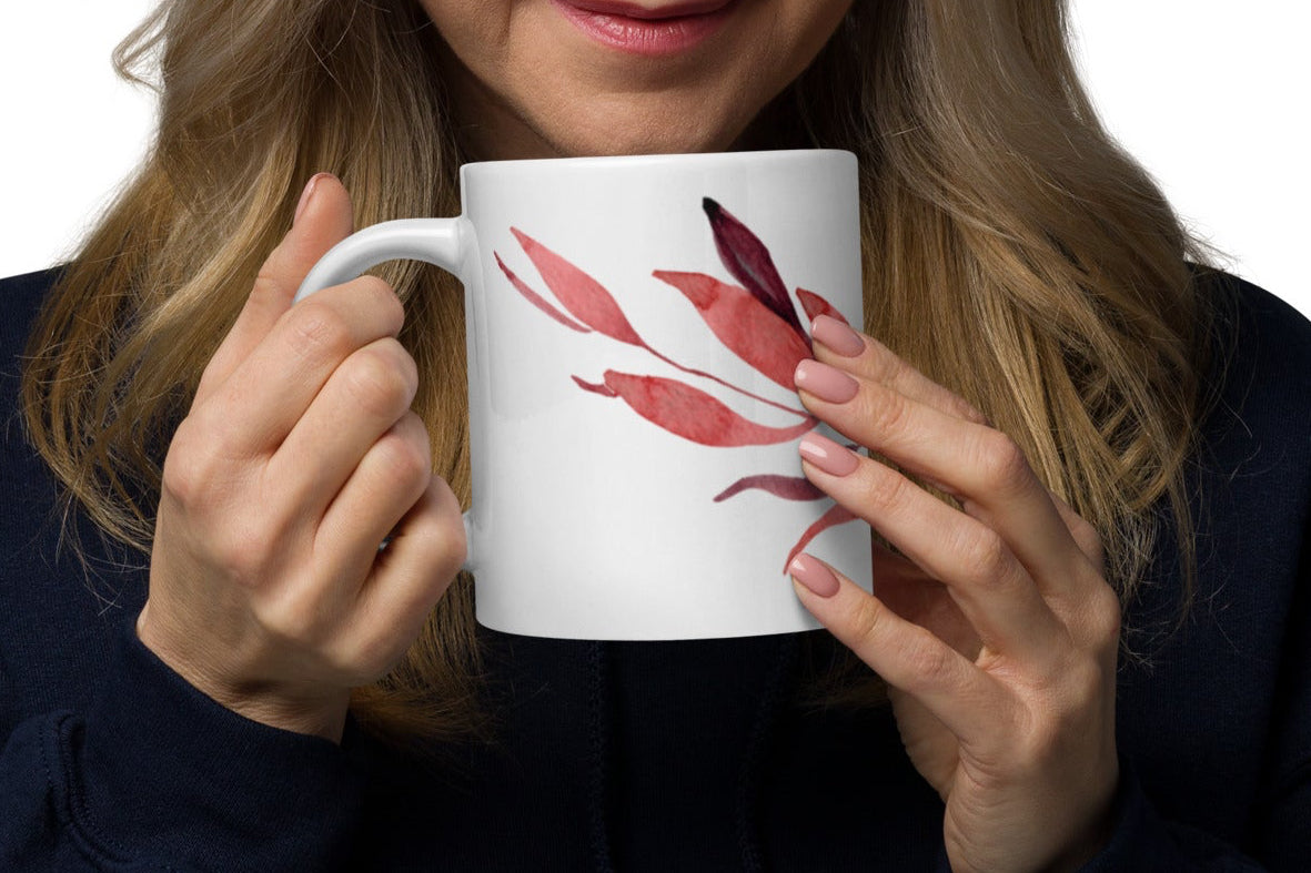 Woman holding a white mug with a floral design on a white background
